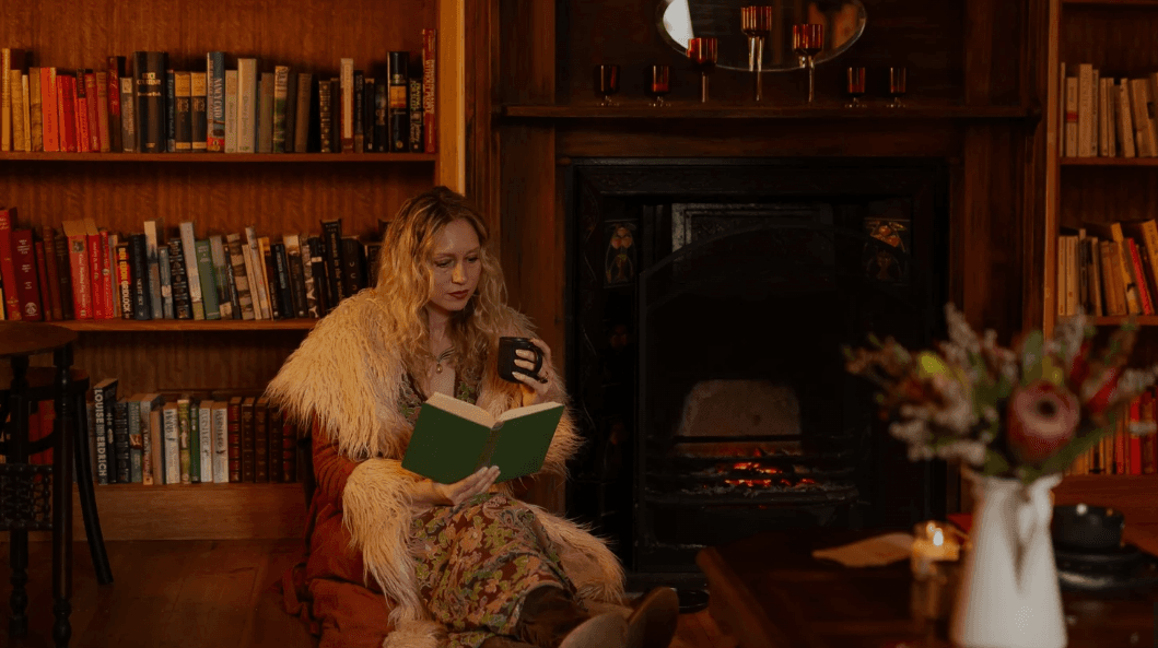The cosy library nook at Cherry Bomb Cafe — armchairs, bookshelves, and a glowing fireplace